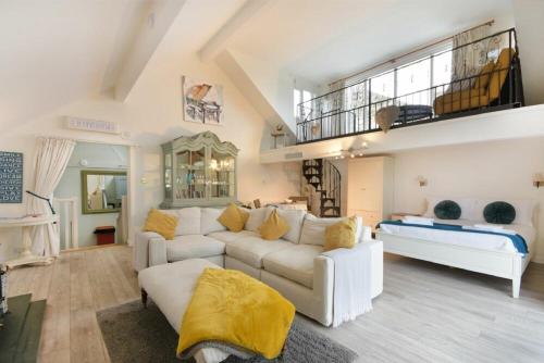 a living room with a white couch and a staircase at The Snug in Embleton