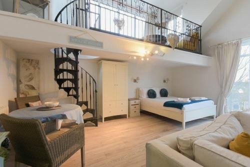 a living room with a bed and a staircase at The Snug in Embleton