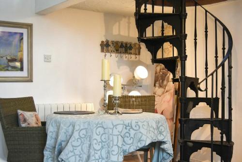 a dining room with a table and a shelf with candles at The Snug in Embleton
