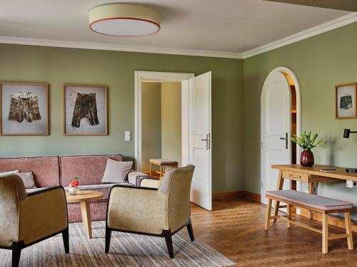 a living room with green walls and a couch and chairs at Spa & Resort Bachmair Weissach, LUXURY FAMILY RESORT in Rottach-Egern