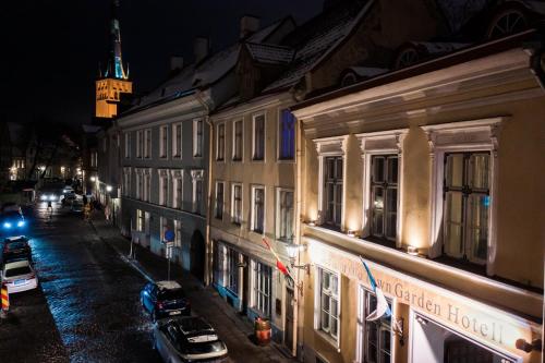 a city street at night with a clock tower at Meriton Old Town Garden Hotel in Tallinn