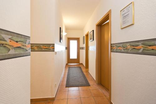 - un couloir dans un immeuble doté de carrelage dans l'établissement Haus am Kölpinsee App 3 3, à Kölpinsee