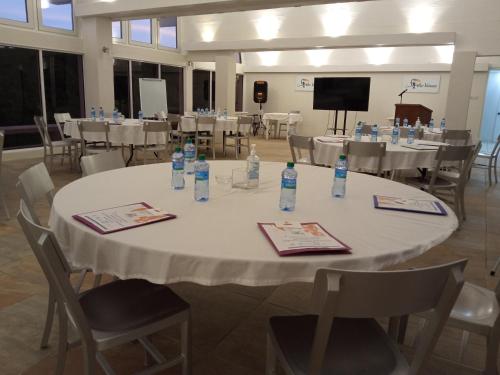 a large room with tables and chairs with bottles on them at Spring Hotel Bequia in Port Elizabeth