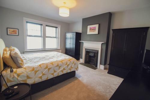 um quarto com uma cama e uma lareira em Beachy Head Apartment By Air Premier em Seaford