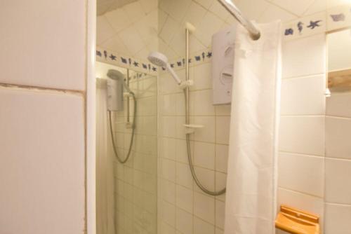 a shower with a shower curtain in a bathroom at Rafters in Alnmouth