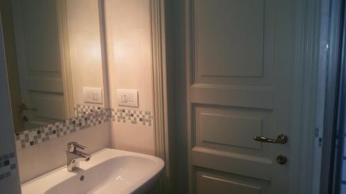a bathroom with a sink and a door with a mirror at Agriturismo Villalta in Ponte Felcino
