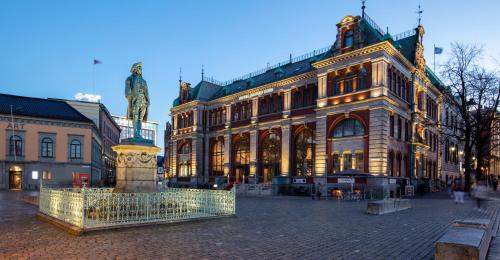 un grand bâtiment avec une statue en face dans l'établissement Bergen Børs Hotel, à Bergen