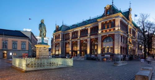 un grande edificio con una statua davanti di Bergen Børs Hotel a Bergen