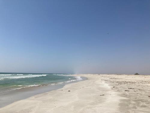a sandy beach with the ocean in the background at Townhouse Paolo in Salalah