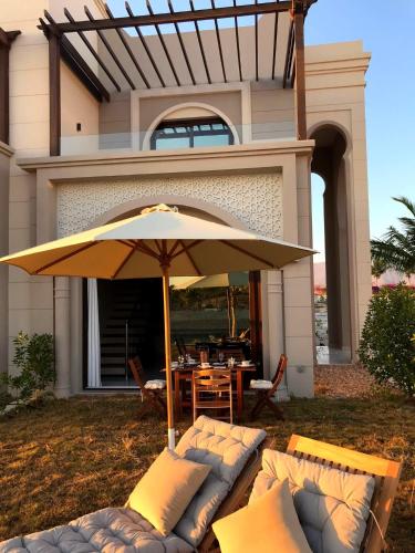 a patio with an umbrella in front of a house at Townhouse Paolo in Salalah
