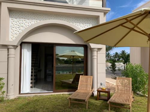 two chairs and an umbrella on a patio at Townhouse Paolo in Salalah