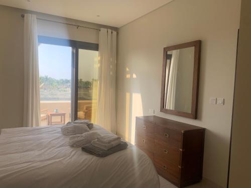 a bedroom with a bed with a dresser and a mirror at Townhouse Paolo in Salalah