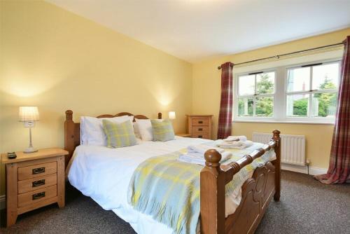 a bedroom with a large bed and a window at Greenfinch in Lucker