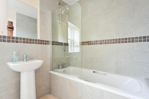 a bathroom with a sink and a bath tub and a sink at Greenfinch in Lucker