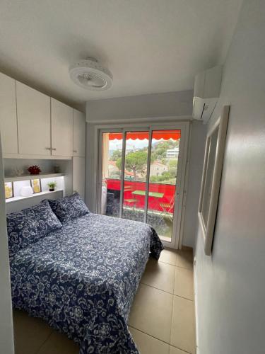 ein kleines Schlafzimmer mit einem Bett und einem Fenster in der Unterkunft Charmant 2 Pièces Vue sur Mer et MONTE-CARLO à ROQUEBRUNE CAP MARTIN in Roquebrune-Cap-Martin