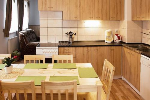 a kitchen with a wooden table with chairs and a kitchen sidx sidx at Chalupa Hela in Loučná pod Klínovcem