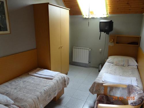 a bedroom with two beds and a tv in it at Penzion Eso in Martin