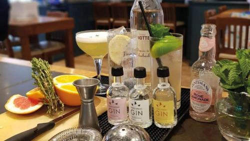 a table topped with bottles and glasses of drinks at The Coach House Inn in Chester