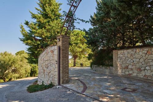a stone fence with a stone wall and trees at Wild Oak Estate - Stunning Views at a Dreamy Location, by ZanteWize in Argasi