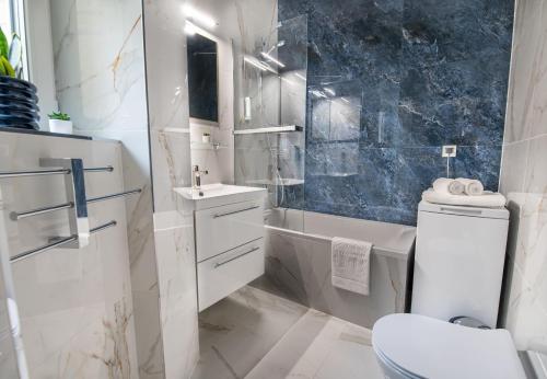 a bathroom with a toilet and a sink and a tub at Apartamenty Yeti & Wilka w Centrum Chorzowa - Yeti in Chorzów