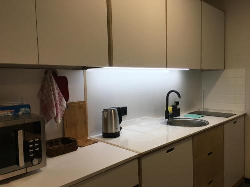 a kitchen counter with a sink and a microwave at Apartment Kokhta-Mitarbi B3 408 in Bakuriani
