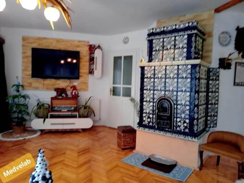 a living room with a fireplace and a tv at Pensiunea Laba Ursului - Medveláb Vendégház in Sovata