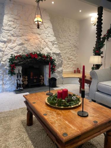 a living room with a fireplace and a table with red candles at 3 Bedroom Cottage, Red Wharf Bay, Pentraeth, Anglesey in Pentraeth