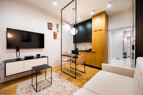 a living room with a white couch and a tv at MOSTOWA Abdank Old Town Apartment in Warsaw