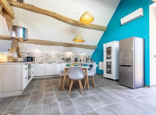 a kitchen with blue walls and a table and chairs at La Bergerie à Palleau, Les Blés Dorés et Les Graines de Lin à Corgengoux, proches de Beaune et de ses villages viticoles in Palleau