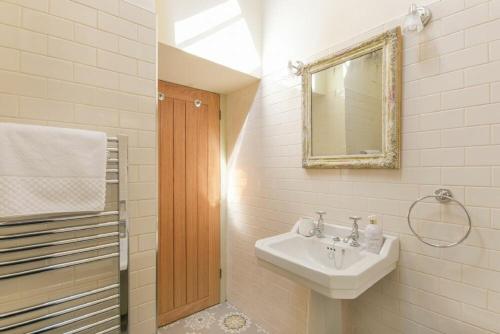 W łazience znajduje się umywalka i lustro. w obiekcie The Blacksmith's w mieście Bamburgh