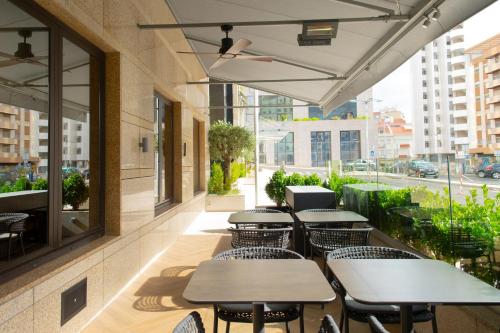 eine Reihe von Tischen und Stühlen auf einer Terrasse in der Unterkunft SANA Metropolitan Hotel in Lissabon