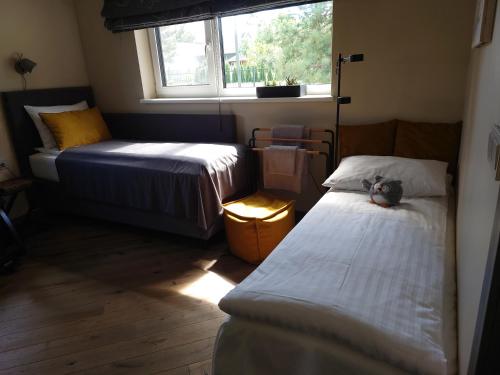 a small bedroom with two beds and a window at MĖTA in Birštonas