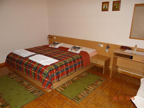 a small bedroom with a bed and a desk at Penzion Eso in Martin