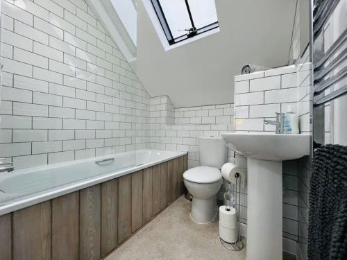 a bathroom with a toilet and a sink and a bath tub at Stable Cottage in Frome