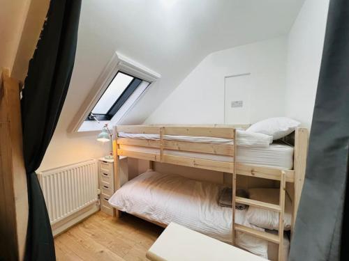two bunk beds in a small room with a window at Stable Cottage in Frome