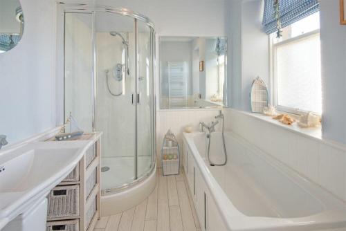 a bathroom with a shower and a tub and a sink at The Villas No3 in Embleton