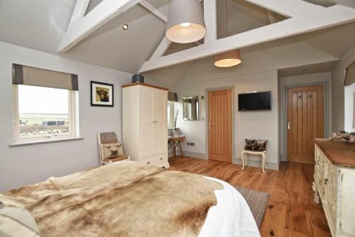 a large bedroom with a large bed and a television at The Hemmel Beadnell in Beadnell