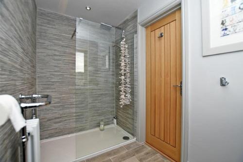 a bathroom with a shower with a glass door at The Hemmel Beadnell in Beadnell