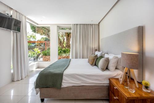 a bedroom with a large bed and a large window at Far Horizons Camps Bay in Cape Town