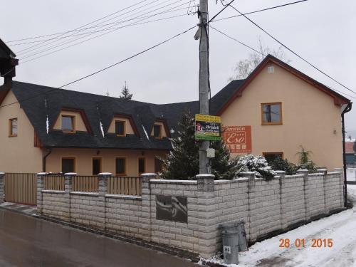 a house with a brick fence in front of it at Penzion Eso in Martin