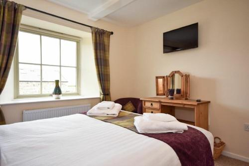 a bedroom with a bed with two towels on it at Castle View Glororum in Bamburgh