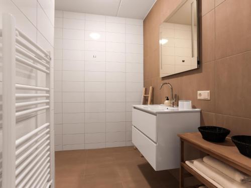 a white bathroom with a sink and a mirror at Amazing apartment in Kamperland with patio in Kamperland