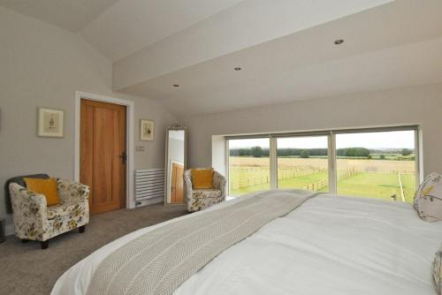 a large bedroom with a large bed and a large window at The Pepper Pot in Warkworth