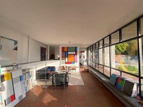 a living room with a large window and a room with a table at Villa Cavalli - Snozzi's Kunstwerk in Verscio