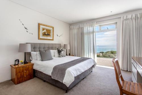 a bedroom with a large bed and a large window at Far Horizons Camps Bay in Cape Town
