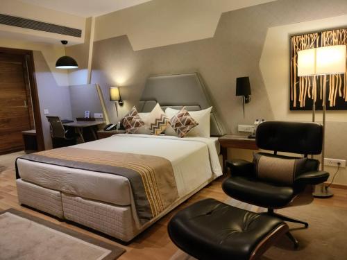 um quarto com uma cama grande, uma secretária e uma cadeira. em Fortune Park, Dahej- Member ITC's Hotel Group em Dahej