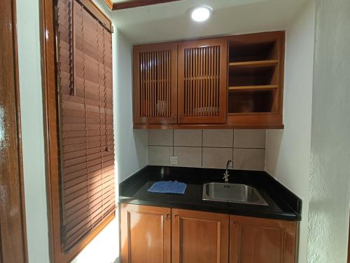 una pequeña cocina con fregadero y armarios de madera. en Pd full seaview deluxe en Port Dickson