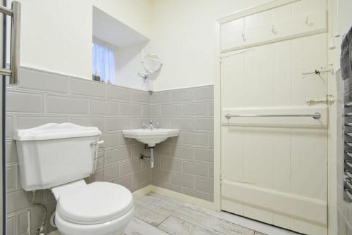 bagno bianco con servizi igienici e lavandino di West End Cottage a Embleton