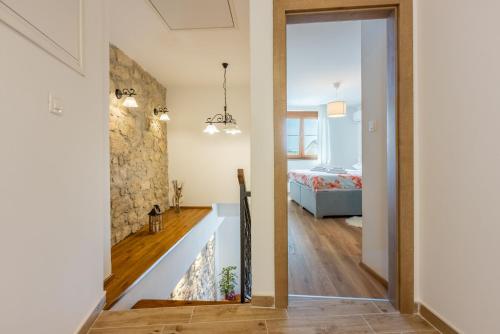 a hallway leading to a bedroom with a stone wall at Villa Banely in Grižane