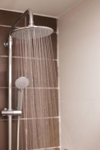 a shower with a shower head in a bathroom at Chiang Roi 7 Days Inn in Chiang Mai